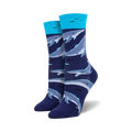 A pair of women's crew socks in navy blue and teal. The socks feature a pattern of whales swimming underwater.
