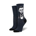 A pair of women's crew socks in dark blue featuring a grayscale portrait of Abraham Lincoln. The socks have black heels and toes.