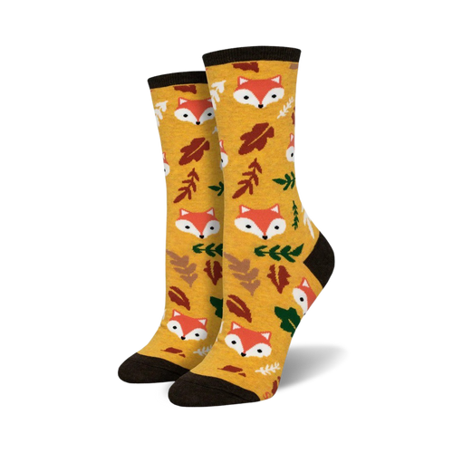 Pair of crew socks in mustard yellow. Features repeating pattern of cute fox faces and autumn leaves.