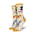 Cream crew socks with a sewing-themed pattern: sewing machines, scissors, thread, and hearts. Yellow cuff.