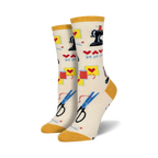Cream crew socks with a sewing-themed pattern: sewing machines, scissors, thread, and hearts. Yellow cuff.
