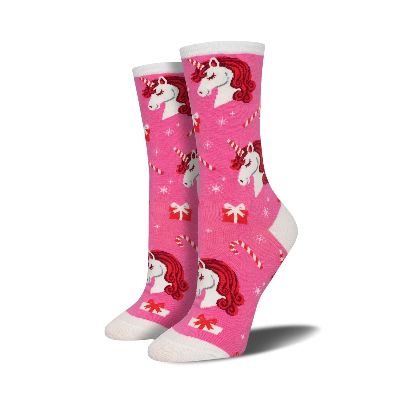 Crew socks in pink featuring red-haired unicorns, candy canes, and presents on a pink background. A festive and fun design!