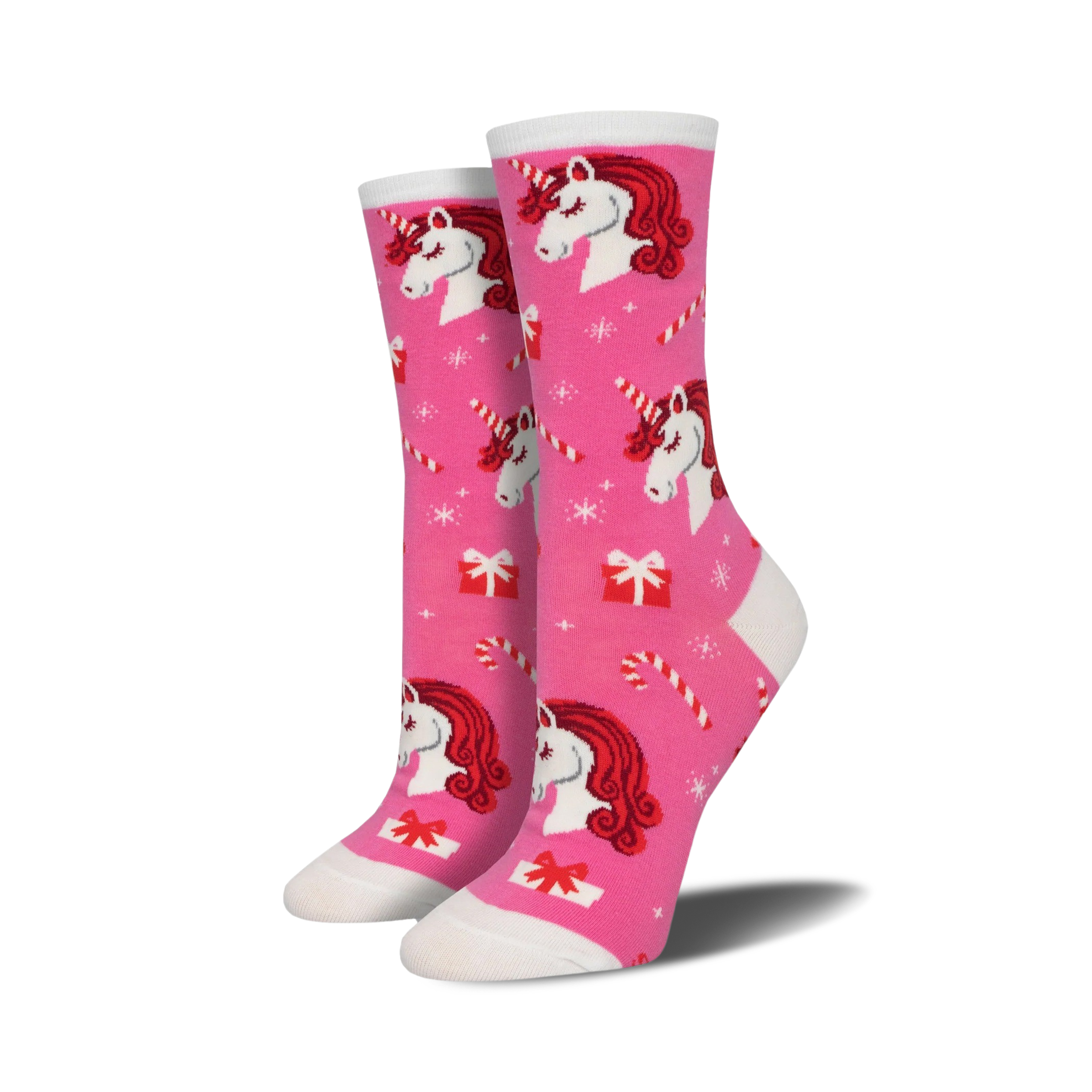 Crew socks in pink featuring red-haired unicorns, candy canes, and presents on a pink background. A festive and fun design!