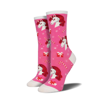 pink and white womens crew socks feature a festive christmas pattern of unicorns, candy canes, snowflakes, and presents.  