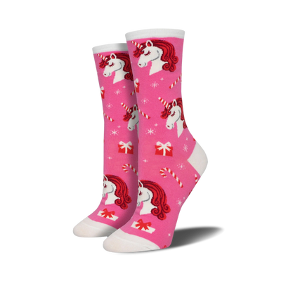 pink and white womens crew socks feature a festive christmas pattern of unicorns, candy canes, snowflakes, and presents.  