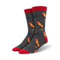Close-up of a pair of charcoal grey crew socks with red cuffs and a repeating rooster pattern.