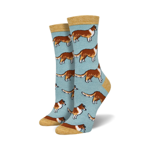 Pair of women's crew socks. Light blue background with repeating pattern of brown and white Collie dogs. Mustard yellow cuff.
