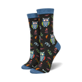Close-up of a pair of black crew socks with owls, leaves, and berries. Blue top trim.