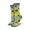 Pair of crew socks with bees, sunflowers, and honeycomb pattern on a sage green background.  Black and grey top cuff.