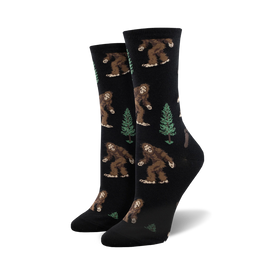crew length socks for women with pattern of bigfoot creatures walking amidst green pine trees  