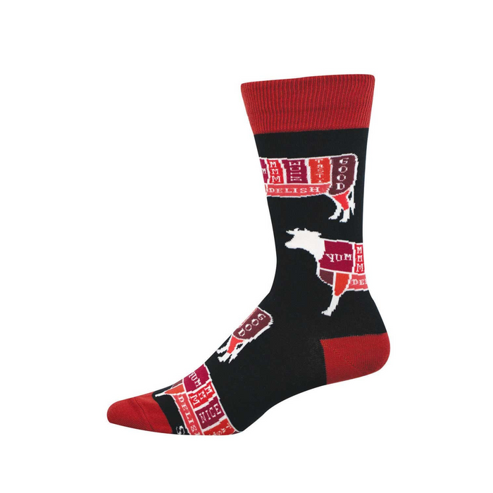 Black crew socks with red cuffs, heel, and toe. Features white outlines of cattle divided into colorful butcher cuts labeled 'YUM' and 'DELISH.' }}