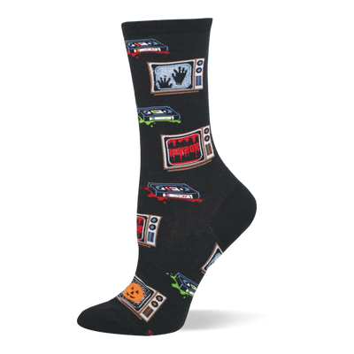 Black crew socks with retro TVs showing 'HORROR', spooky hands, and jack-o'-lanterns, plus VHS tapes with red and green splatters.