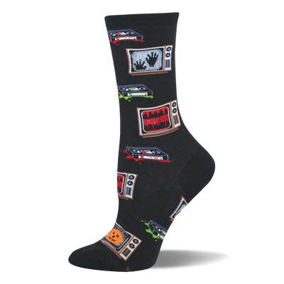 Black crew socks with retro TVs showing 'HORROR', spooky hands, and jack-o'-lanterns, plus VHS tapes with red and green splatters.