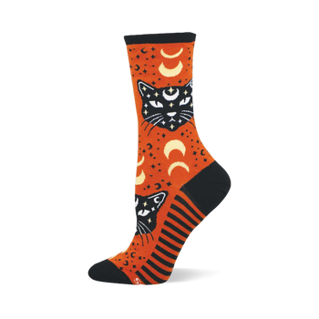 Orange crew sock with black mystic cats, white eyes, crescent moons, and stars. Features black toe, heel, cuff, and striped side panel.