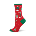 Red crew socks with green accents, featuring festive moose in teal sweaters and beanies, plus green Christmas trees and white snow.