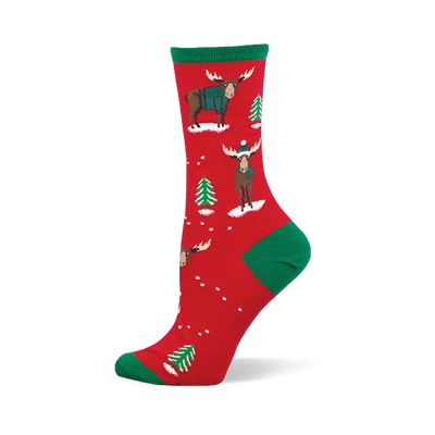 Red crew socks with green accents, featuring festive moose in teal sweaters and beanies, plus green Christmas trees and white snow.