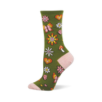 An olive green crew sock with pink toe, heel, and cuff, featuring a retro pattern of daisies, butterflies, hearts, and a mushroom.