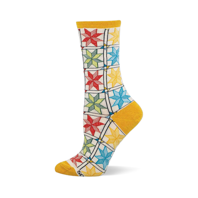 Single crew sock with colorful quilt pattern: red, green, blue, yellow star blocks on cream, with mustard heel, toe, cuff.