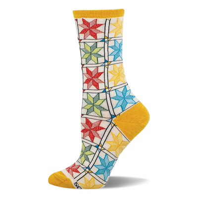 Single crew sock with colorful quilt pattern: red, green, blue, yellow star blocks on cream, with mustard heel, toe, cuff.