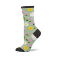 Light green crew socks with pink smiling worms, white and yellow flowers, and green leaves. Dark brown heel, toe, and cuff.
