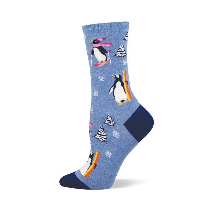 Light blue crew sock with skiing and snowboarding penguins, white snowflakes, and snow-covered pine trees. Dark blue heel and toe. }}