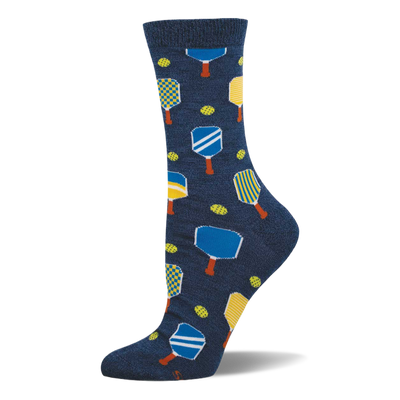 Navy blue crew socks with a repeating pattern of yellow, blue, and white pickleball paddles and yellow-green pickleballs.