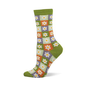 Side view of a crew sock with a checkerboard of light green, orange, and purple squares, each with a white daisy. Dark green cuff, heel, and toe.