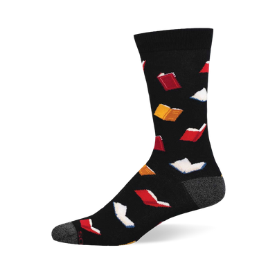 A black crew sock with a scattered pattern of small open books in red, white, and yellow. Grey heel and toe details.