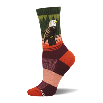 Crew sock with a bald eagle perched on a stump. Dark green cuff, green tree pattern, orange and brown stripes, color block foot.