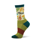 Crew sock with "Stay Wild" text, green and orange leaves, yellow flowers on a cream background. Teal cuff, heel, toe. Green/brown stripes.
