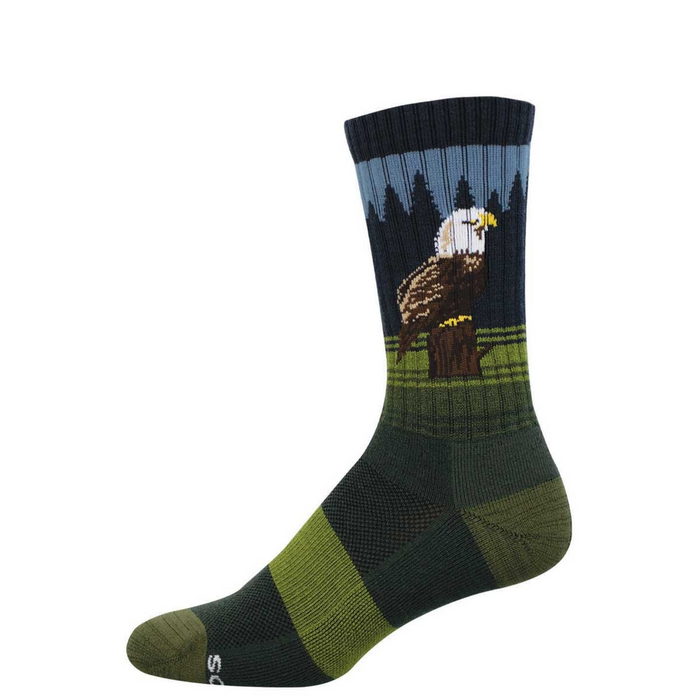Crew sock with a bald eagle perched on a stump, dark pine trees, and blue sky. Green and dark green stripes on foot. }}
