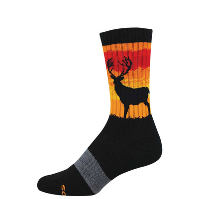 A black crew sock featuring a black stag silhouette against a striped red, orange, and yellow sunset design on the calf.