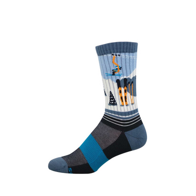 Crew sock with a ski slope design. Features a blue sky, white snow, orange ski lift, skier, black pine trees, and orange skis. Dark blue foot.