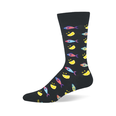 Black crew sock patterned with small colorful striped fishes and bright yellow lemon wedges, featuring a solid black toe.