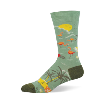 Light green crew sock showing a tropical scene with pink flamingos, a yellow sun, palm trees, and dark olive heel and toe.