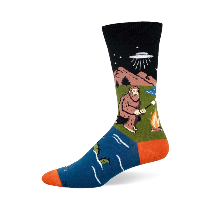 Crew sock with black top, blue foot, and orange heel/toe. Features Bigfoot by a fire, a UFO, and a swimming sea monster. }}