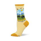 Light yellow socks showing a Yellowstone National Park scene with bison, geysers, pine trees, and mustard yellow accents.