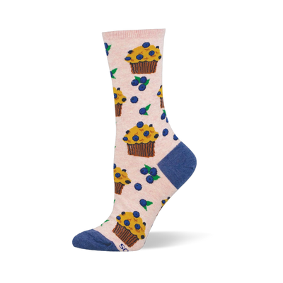 Light pink crew socks patterned with yellow blueberry muffins in brown wrappers and scattered blueberries with green leaves.