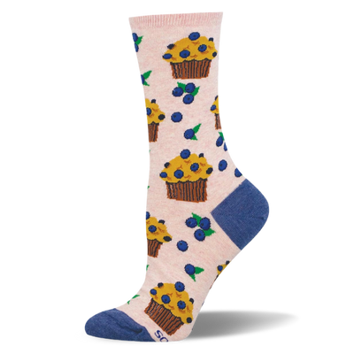 Light pink crew socks patterned with yellow blueberry muffins in brown wrappers and scattered blueberries with green leaves.