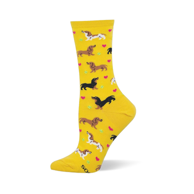 Yellow crew socks featuring brown dachshunds, spotted dachshunds, pink hearts, and green tennis balls.