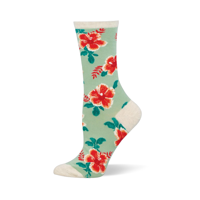 Mint green crew socks covered in red and orange hibiscus flowers with dark green leaves. The cuff and heel are cream colored.