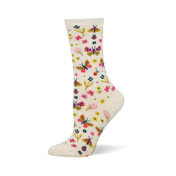 Cream crew socks showing a colorful pattern of pink and yellow butterflies, assorted small flowers, and tiny red ladybugs.