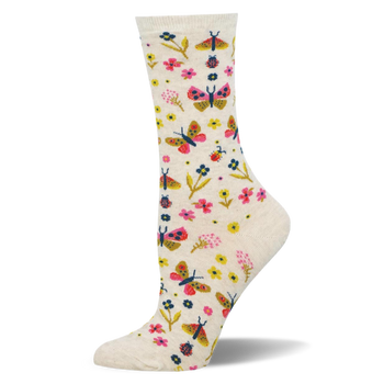 Cream crew socks showing a colorful pattern of pink and yellow butterflies, assorted small flowers, and tiny red ladybugs.