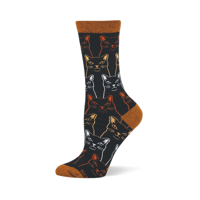 Black bamboo crew sock covered in outlined, sketchy cat faces in white, gold, and orange, with a rust orange toe and heel.