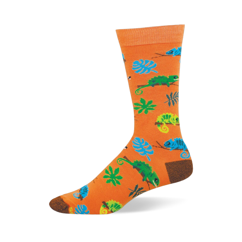 Bright orange crew sock featuring a pattern of blue and green chameleons on branches, tropical leaves, and tiny bugs.