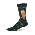 Black bamboo crew sock featuring a large brown owl with yellow eyes perched on a branch, bordered by green leafy patterns.