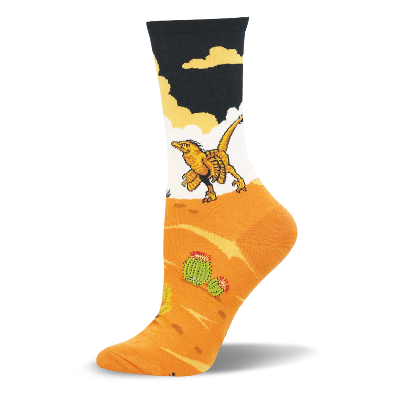 Crew sock featuring a yellow velociraptor walking across a white background above an orange desert with green cacti.