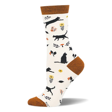 Cream bamboo sock with rust cuff, heel, and toe. Pattern shows black cat silhouettes, yellow flowers, and orange mushrooms.