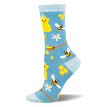 Light blue bamboo socks with a pattern of yellow honey bear bottles, flying bees, honeycombs, and wooden spoons.