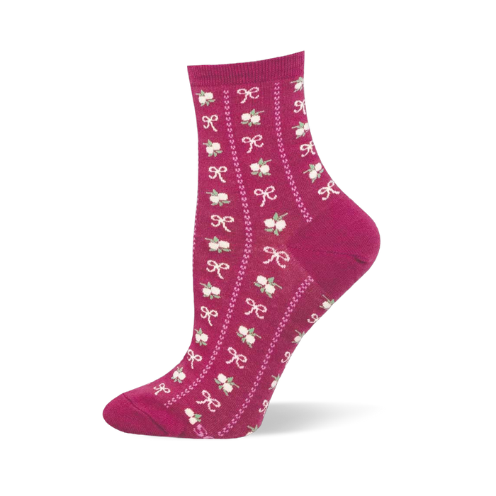 Close up detail of a blue sock showing the knitted texture of small pink bows and green and pink floral bouquets.